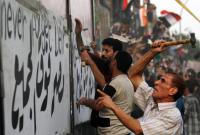 Die Mauer vor der israelischen Botschaft wird von Demonstranten eingerissen.