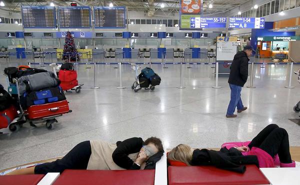Auf den Flughäfen vertreiben sich die Passagiere die Zeit. - Foto: AFP