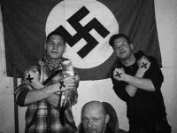 Dennis Brandt, Jörn Gronemann und Dennis Giese hinter einer Hakenkreuzflagge