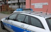 Ein Streifenwagen der Polizei steht in Neustadt vor der Wand eines Hauses mit dem Schriftzug «Oury Jalloh - Das war Mord»
