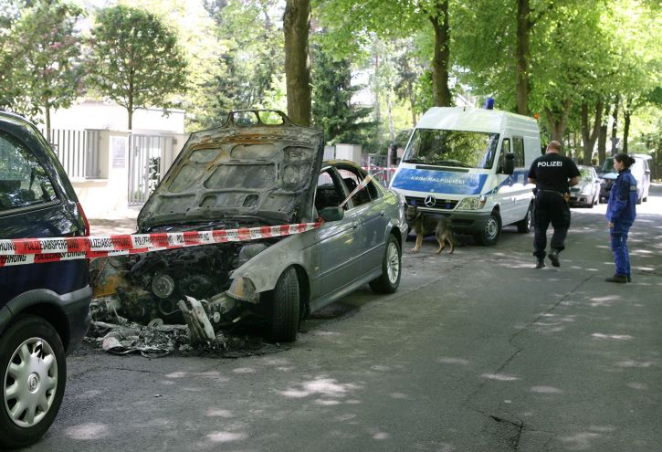 Verkohlte Front: Ein Ermittler an dem abgebrannten BMW vor dem Anwesen in der Seepromenade, in dem die SPD-Europaabgeordnete Dagmar Roth-Behrendt mit ihrem Mann, dem EU-Spitzenbeamten Horst Reichenbach, wohnt. Foto: Andreas Klaer