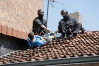 Aktivist kopfüber auf dem Dach