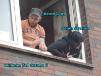 Kevin Gräf und Sina Straus zeigen sich dem Demonstrationszug am Fenster ihrer Wohnung. 