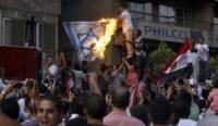 Egyptian activists burn a depiction of an Israeli flag as they demolish a concrete wall built around a building housing the Israeli embassy in Cairo, September 9, 2011
