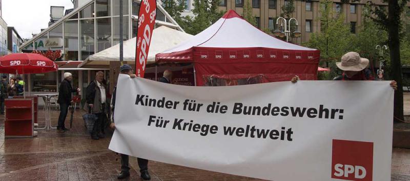 Aktionen des Friedensplenums bei SPD, CDU und Grünen-Ständen während des Wahlkampfs.