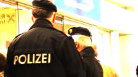Zwei Polizisten* machen beim Ticket-Schalter von Brüssel Airline den Aktivist_innen Stress