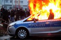 Brennende Polizeiwagen bei den Protesten des Blockupy-Bündnisses auf der Hanauer Landstraße.  Foto: Peter Jülich