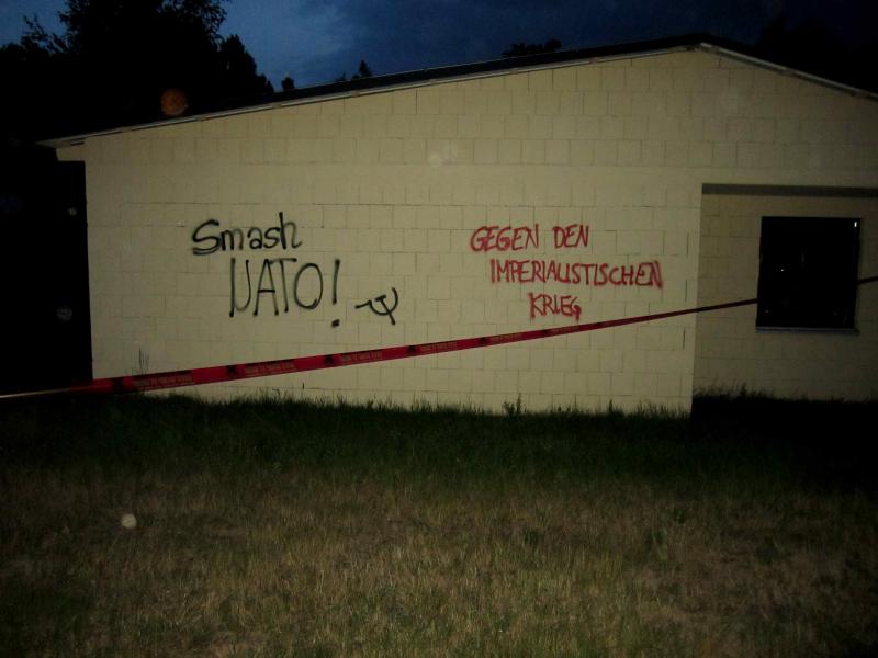 "Smash Nato", "Gegen den imperialistischen Krieg", davor gespanntes Absperrband ("War Starts Here, Let's Stop It Here")