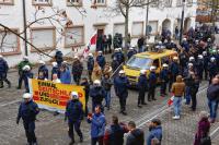   Oft mit dabei, wenn die NPD marschiert: Boxsport-Jugendtrainer Siegfried Pauly (rechts am gelben Plakat) mit rechtsnationalen Wegbegleitern beim Demonstrationszug im Februar in Singen – umringt von Polizeibeamten.