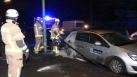 Feuerwehrleute untersuchen das in der Alexandrinenstraße angezündete Auto Foto: spreepicture