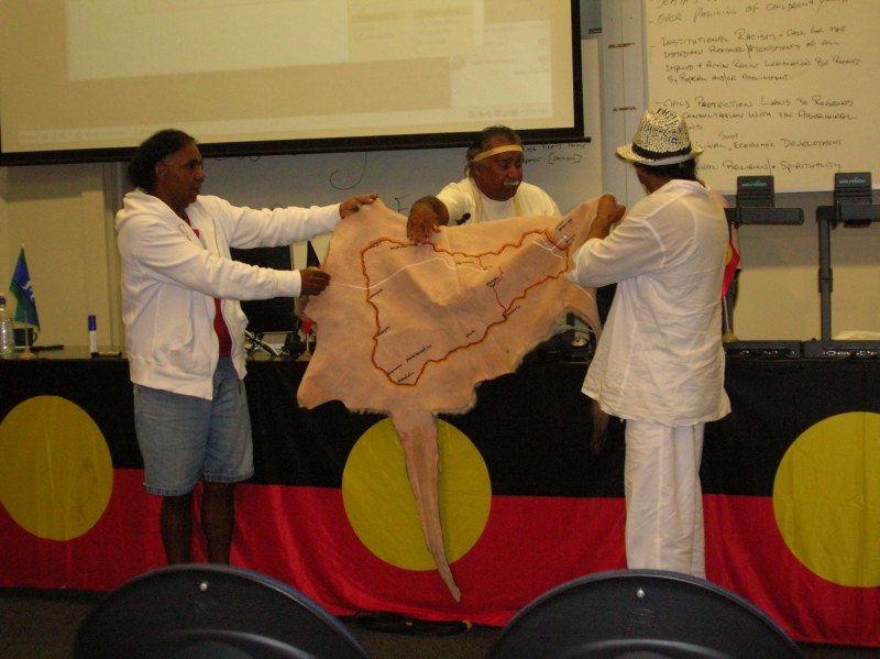 Githabul men and Michael Anderson showing the conference Githabul country on two joined kangaroo skins, and song lines running right across Australia, up to the Morning Star and back down to northern NSW. 