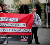 Fabian Knop (rechts) hält das Trans­pa­rent der Ber­liner NPD auf einer Kund­ge­bung, 20. August 2013