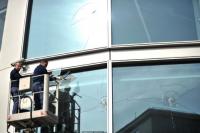 Nach den Krawallen vom Wochenende entfernen zwei Monteure am Montag entfernen eine eingeschlagene Fensterscheibe an der Fassade der Commerzbank.Foto: dpa