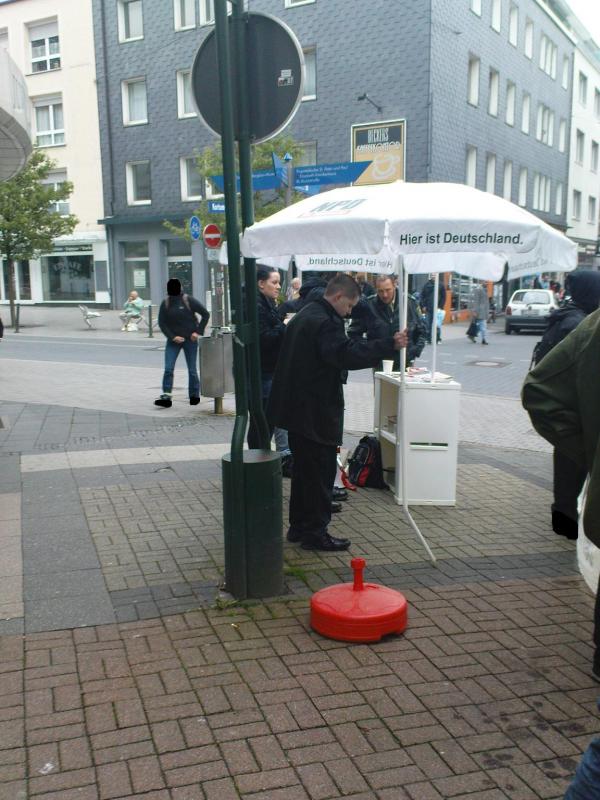 NPD Stand am 8.5.: Schumacher hält den kaputt-getretenen NPD-Schirm fest