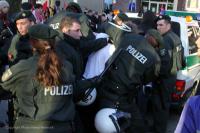 Demonstrant wird abgeführt - Bulle mit Schlagstock wendet sich ab