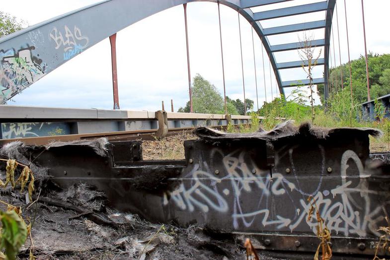 Verkohlte Überreste zeugen von dem nächtlichen Brand an der Hennigsdorfer Bahnbrücke über die Havel-Oder-Wasserstraße. Ermittler des polizeilichen Staatsschutzes sicherten Spuren.