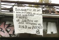 1 Transpi in Solidarität mit den Anarchist_innen, die des Bankraubs in Aachen beschuldigt sind