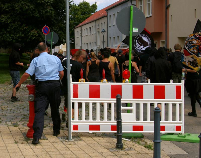 Ein einzelner Polizist entert die Demonstration.