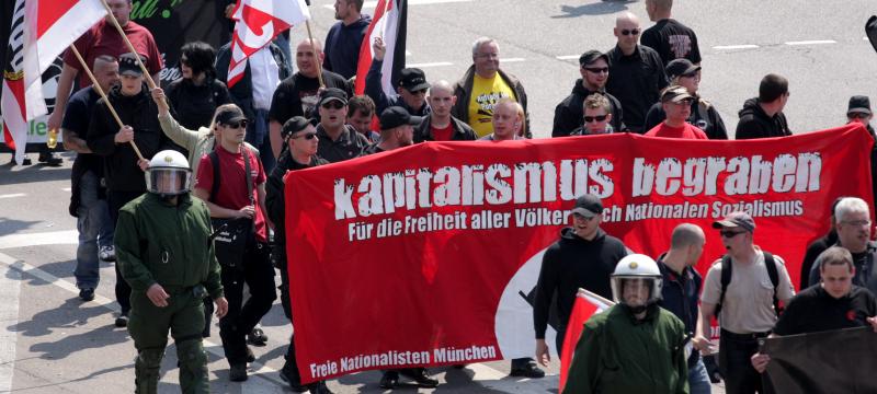 Baumann im roten T-Shirt links neben dem Transparent als „Nationaler Sanitäter“ am 1. Mai 2009 in Ulm