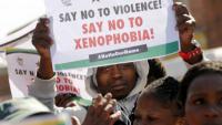 Demonstrators hold placards outside a court in Johannesburg's Alexandra township as four men appeared in court for the killing of a Mozambican man, April 21, 2015. | Photo: Reuters