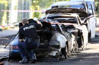 Ein Ermittler der Hamburger Polizei untersucht einen ausgebrannten Porsche.