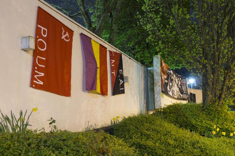 Flaggen und Guernica-Banner am Kriegsmahnmal in Neunkirchen (Saar)