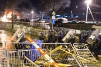 Polizei kämpft sich vor, im Hintergrund brennende Autos der SBB