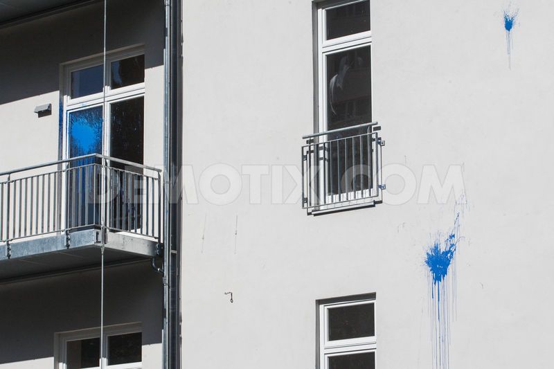 The facade of the apartment building with several paint spots. 
