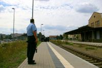 Die Demo ist zuende; die Teilnehmer_innen warten auf den Zug, während ein Polizist die Menschen im Auge behält und Fotos anfertigt.