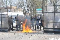 Molotov Cocktails und Leuchtfeuermunition verdrängen die Polizei von ihrer Stellung. Anschließend prasselt ein Steinhagel auf sie nieder.