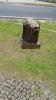 Das Denkmal. Ein Feldstein in einem eisernen Baumstumpf. Daneben: Gedenkbuch aus Metall