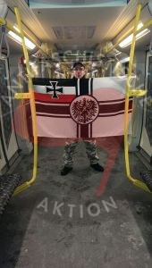 NPD­ler An­dre­as K. po­siert in der U5 an der Halt­stel­le Cott­bus­ser Platz mit einer Reichs­kriegs­flag­ge / Quel­le: In­ter­net