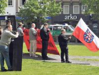 NPD-Kundgebung in Northeim: Marco Borrmann (links) spricht. Die thüringische Landesfahne weht im Vordergrund (rechts).